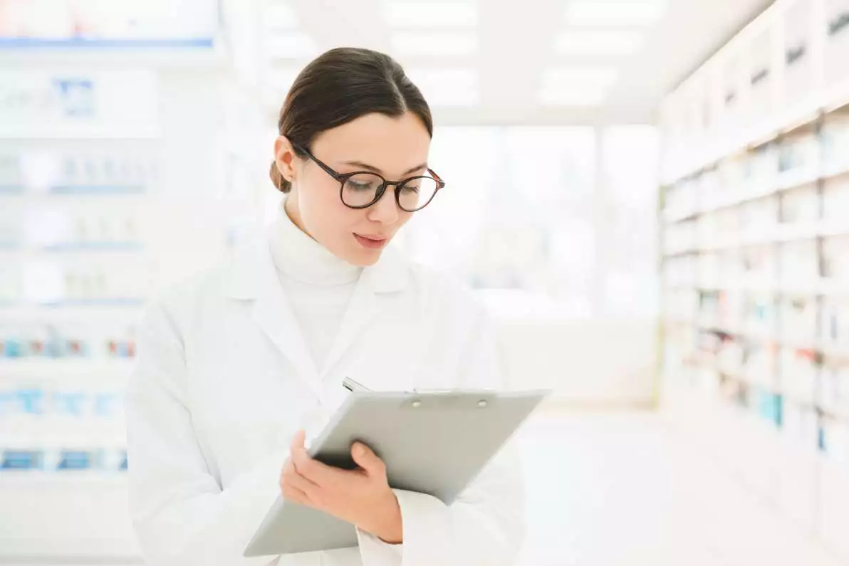 Jeune pharmacienne en blouse médicale blanche, pour illustrer les effets secondaires.