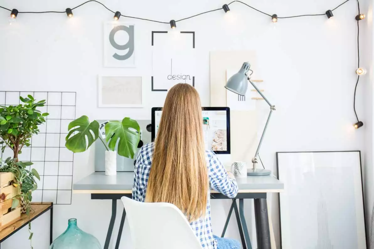 Une jeune fille avec de longs et beaux cheveux, assise dans un bureau.