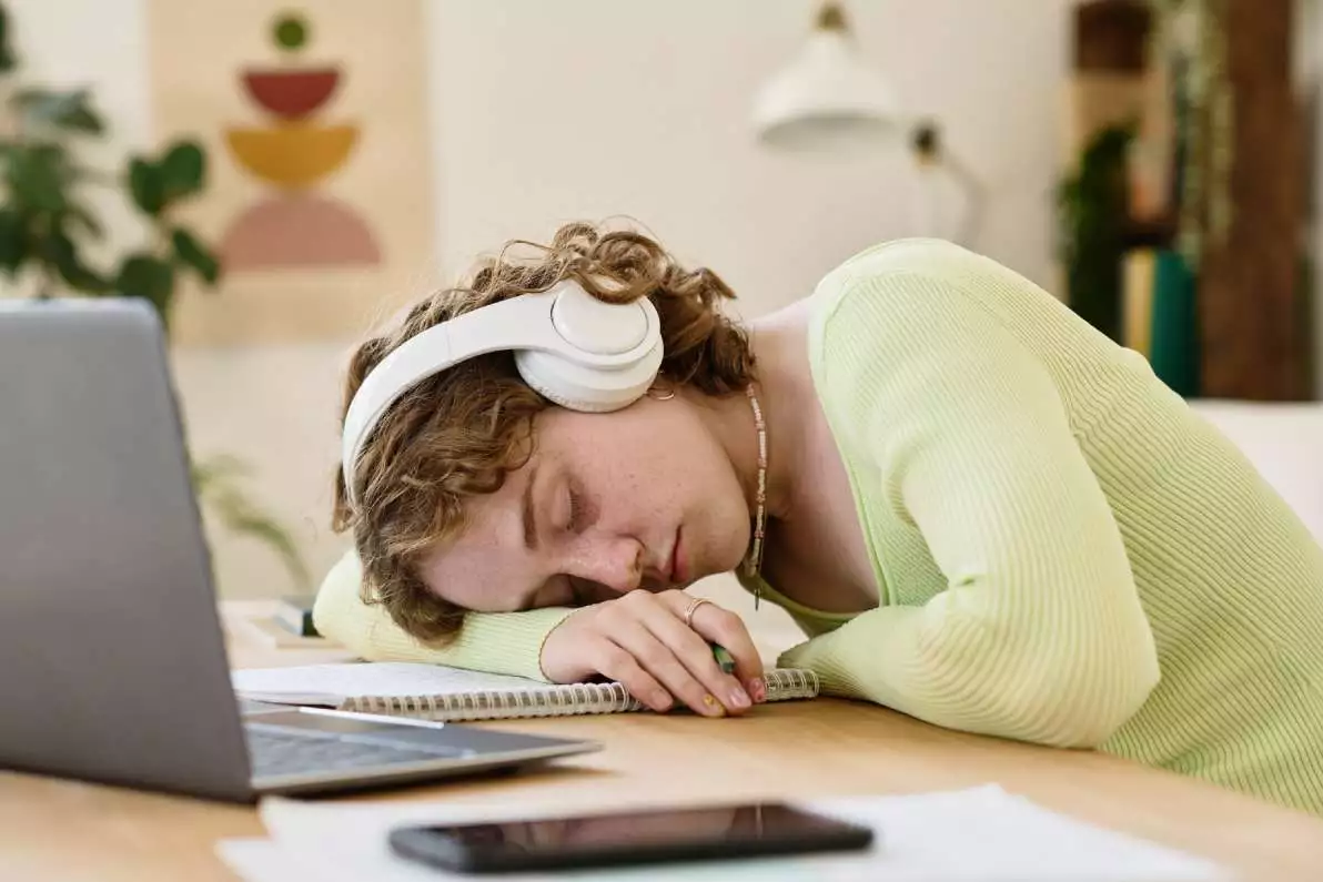 Une jeune fille s’est écroulée de fatigue sur son ordinateur à son bureau.