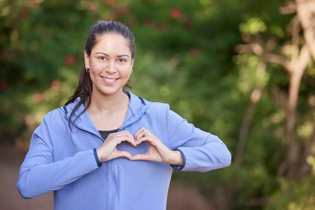 Femme avec les mains en forme de coeur pour illustrer la santé cardiovasculaire.