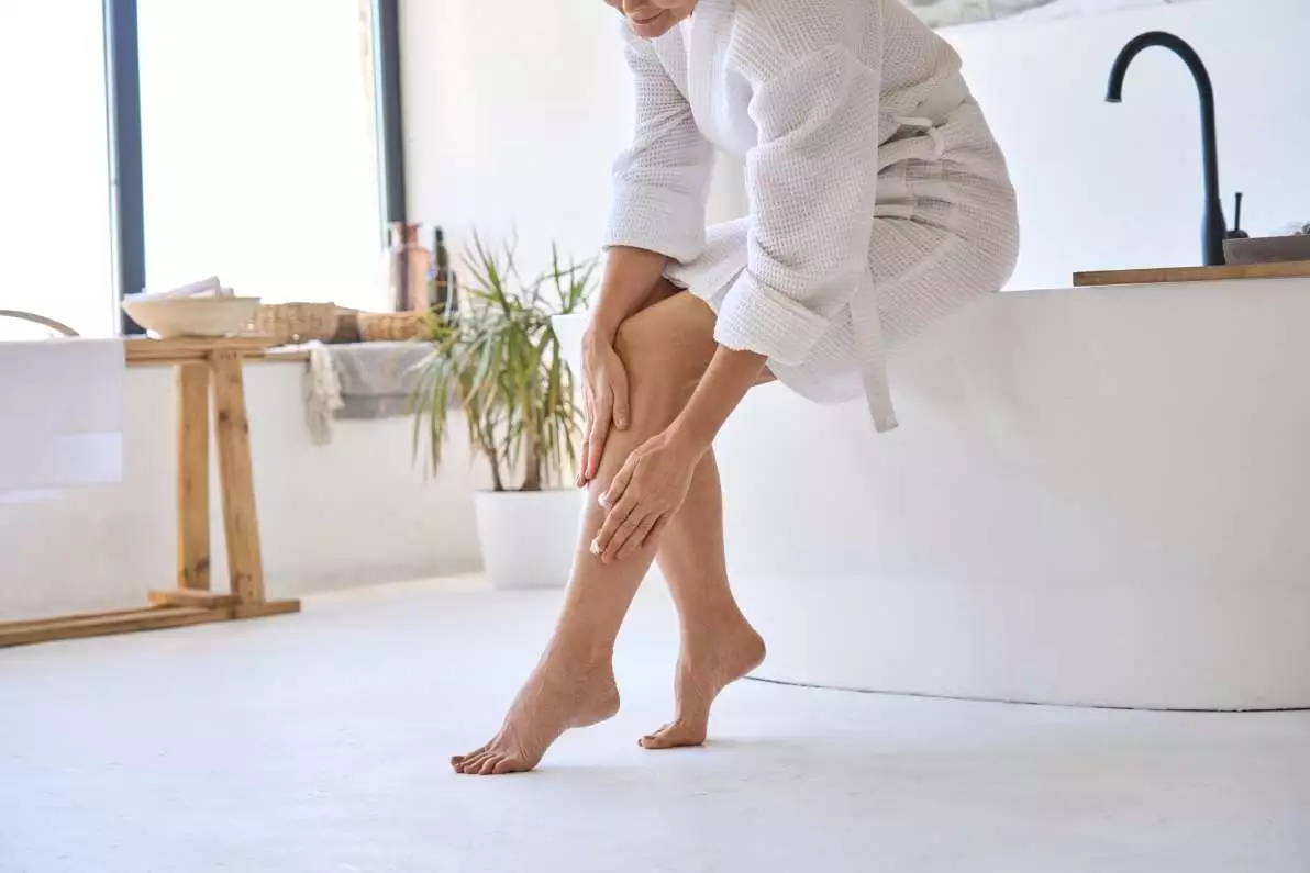 Une femme dans sa salle de bain prends soin de sa peau.