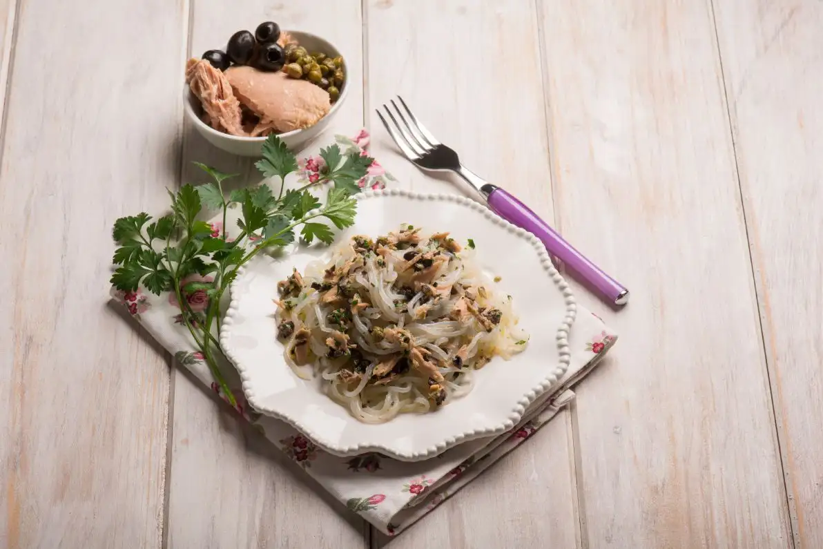 Une assiette composée de spaghetti shirataki au thon, olives noires et câpres